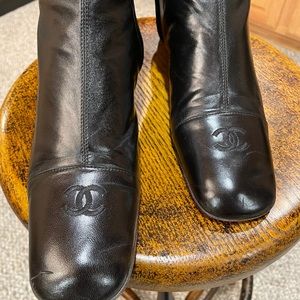A pair of black leather CHANEL boots.